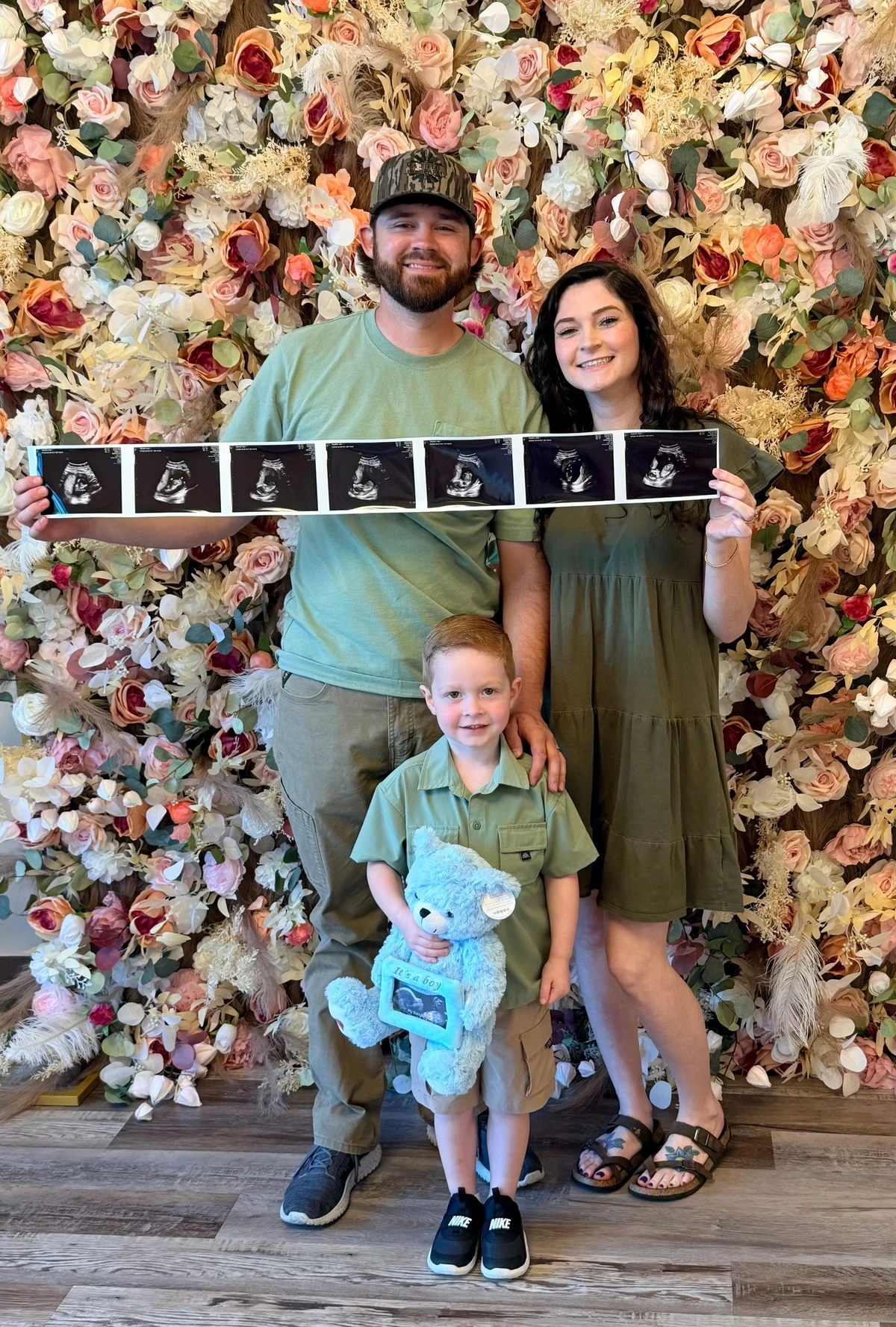 A family holding their ultrasound prints together in the studio